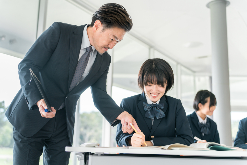 高校教員が女子高生に指導している写真